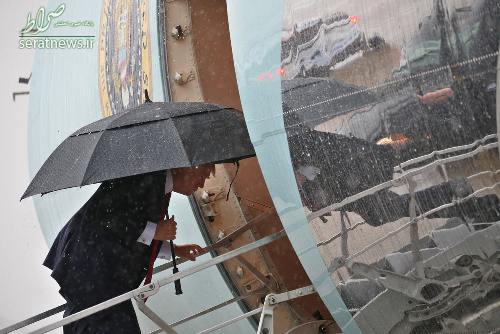 عکس/ ترامپ با چتر در باران شدید