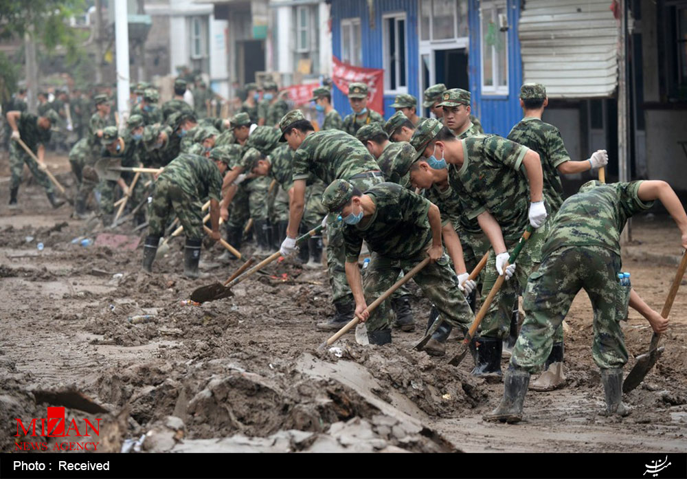 عکس/ پاک کردن گل و لای سیل در چین