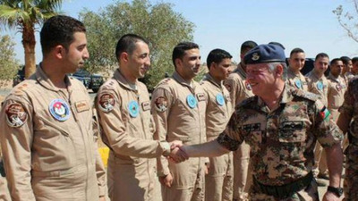 معاذ الکساسبه خلبان اردنی به گروگان گرفته شده توسط داعش، نفر اول از سمت چپ، در دیدار با پادشاه اردن