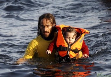  یک نجات غریق داوطلب کودک سوری را از قایقی که 150 پناهجوی سوری در آن بودند به ساحل جزیره لسبوس در یونان منتقل می‌کند.