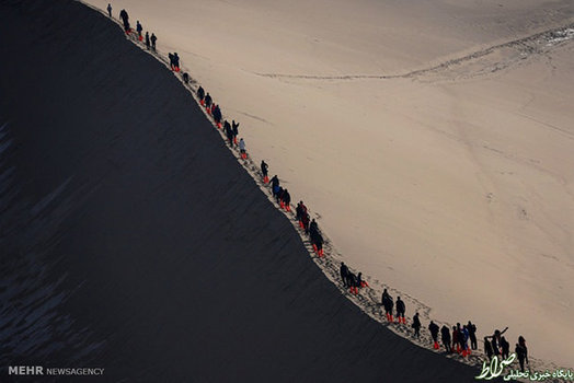 پیاده روی گردشگرها روی کوه های شنی استان «گانسو» چین (Xinhua)