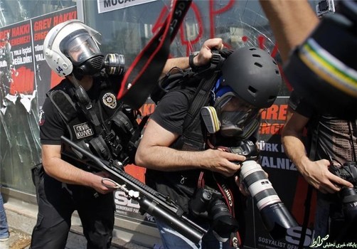  پلیس ضدشورش ترکیه یک عکاس خبری را طی درگیری‌هایی در استانبول در 11 ژوئن 2013 هُل می‌دهد.