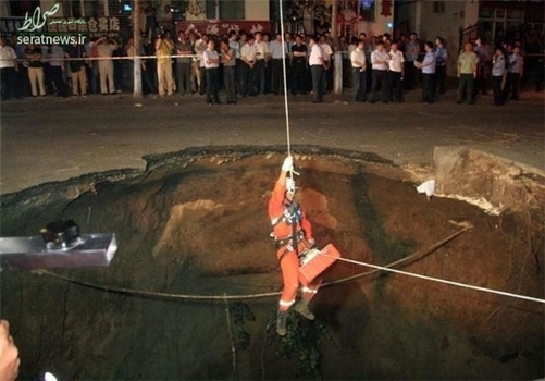  آتشنشان در حال ورود به حفره بزرگی به عمق 10 متر در یکی از خیابان‌های شهر هاربین چین