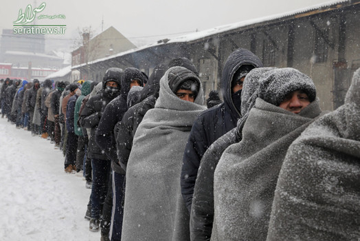 مهاجران و پناهجویان در صف گرفتن غذا در هوای سرد و برفی بلگراد صربستان. این مهاجران در یک انبار متروکه زندگی می کنند