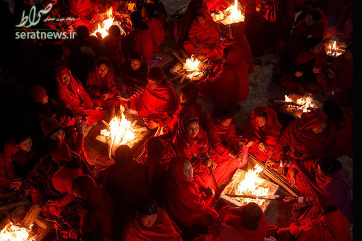 زنان هندو نشسته دور آتش قبل از گرفتن حمام مقدس در رودخانه سالی در حاشیه برگزاری جشنواره ای مذهبی - کاتماندو، نپال