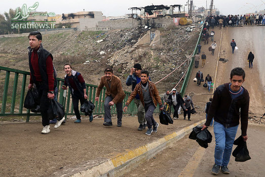 عبور مردم موصل از یک پل شکسته شده پس از آزادسازی یک محله از دست داعش