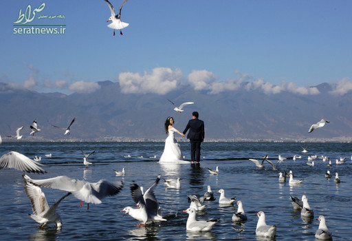 قدم زدن یک عروس و داماد بر روی دریاچه ای در استان یوننان چین