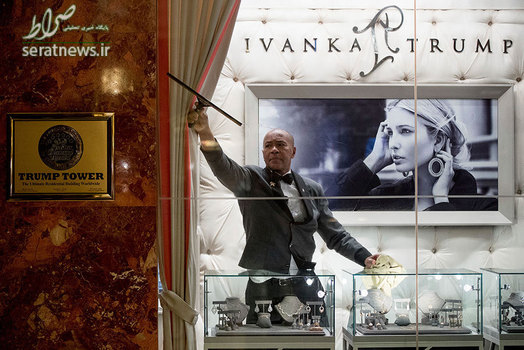 کارگری در حال تمیز کردن شیشه برج ترامپ در نیویورک و تصویری از ایوانکا ترامپ دختر رییس جمهور آمریکا بر روی دیوار
