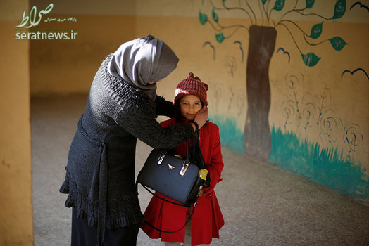 مادر عراقی در حال آماده کردن دخترش برای فرستادن به مدرسه - موصل، عراق