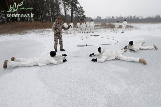 یک افسر ارتش لتونی در حال آموزش به سربازان آمریکایی در طول برگزاری دوره بقا در زمستان