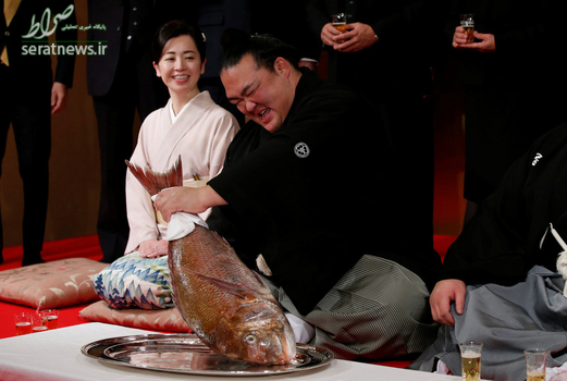 کیسه‌نوساتو یوتاکا یک ورزشکار کشتی سومو در کنار همسرش پس از دریافت عنوان قهرمان بزرگ