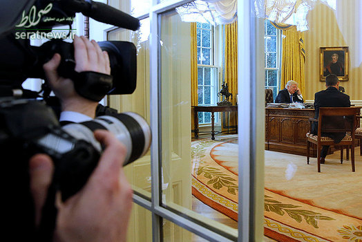 عکاسان در حال عکاسی از دونالد ترامپ رییس جمهور آمریکا که در حال گفتگوی تلفنی با آنگلا مرکل صدراعظم آلمان است