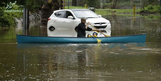  وقوع سیل در شمال کالیفرنیا و تلاش یک مرد و یک پسر برای عبور از خیابان آب گرفته با قایق