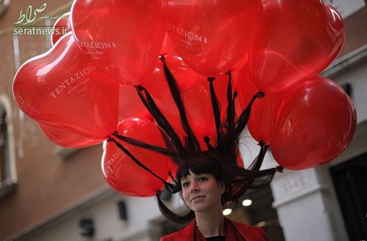 یک زن شرکت کننده در کارناوال ونیز موهای خود را به دهها بادکنک بسته است