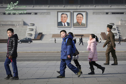 عبور کودکان کره شمالی از مقابل پرتره رهبران کره شمالی؛ کیم ایل سونگ و کیم جونگ ایل - میدان کیم ایل سونگ در پیونگ یانگ