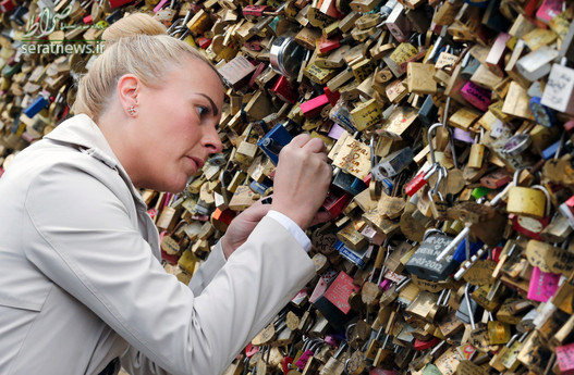 بستن قفل عشق بر روی پل پونت نئوف قدیمی‌ترین پل ایستاده در سراسر رودخانه سن در پاریس در روز والنتاین