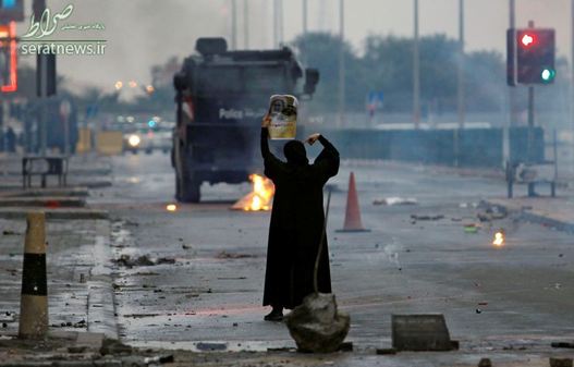 بانوی بحرینی با عکسی از شیخ عیسی قاسم در  سالروز انقلاب 14 فوریه