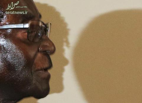 رابرت موگابه رییس جمهور زیمباوه که در یک جلسه سیاسی در حراره شرکت کرده، در این تصویر سایه گریس ماروفو همسر موگابه بر روی دیوار افتاده