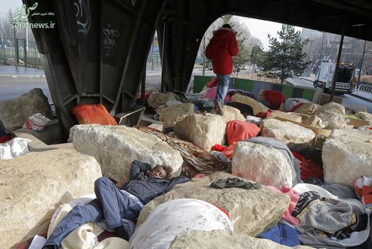 مهاجران و پناهجویان در شهر پاریس زیر یک پل راه آهن که مملو از سنگ های بزرگ است سکنی گزیده اند