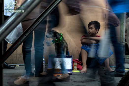 تکدی گری یک پسر با سگ خود در یکی از خیابان های شهر مانیل فیلیپین