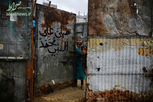 کودکان فقیر فلسطینی مقابل منزل خود پس از بارش سنگین باران در اردوگاه پناهندگان جبلیه در شمال نوار غزه