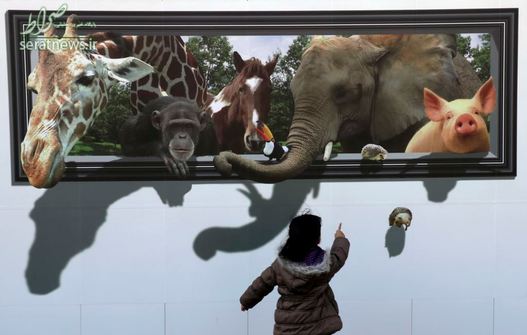 یک دختر مقابل تصویری سه بعدی از حیوانات در توکیوی ژاپن