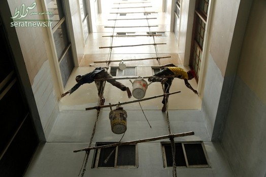 رنگ کاری دیوار یک ساختمان به شیوه نقاشان بنگلادشی در داکا