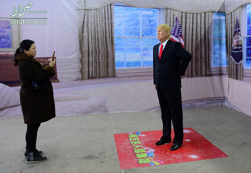 عکس گرفتن یک زن از مجسمه مومی دونالد ترامپ رییس جمهور آمریکا در یک موزه - لیائونینگ، چین