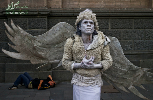 یک هنرمند خیابانی با پوشش فرشتگان در خیابان های شیلی