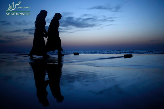 راه رفتن دختران فلسطینی در غروب آفتاب بر روی شن های ساحل غزه