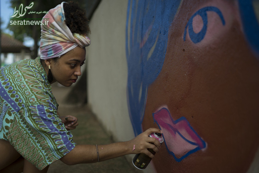 ویانا رودریگز هنرمند خیابانی در حال کشیدن یک طرح دیواری برای پایان دادن به خشونت علیه زنان در ریودوژانیروی برزیل