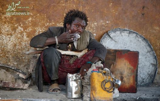 یک مرد آواره از جنگ داخلی سومالی در حال خوردن وعده غذایی ذرت در اردوگاهی در موگادیشو