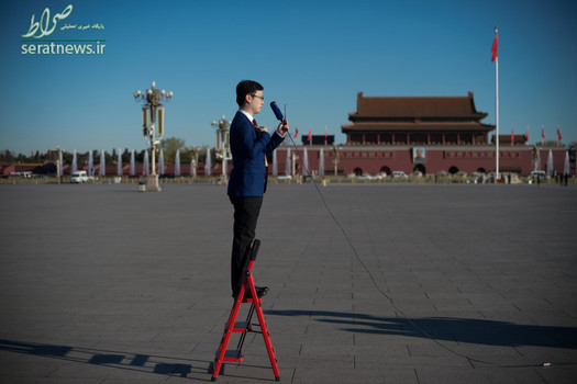 یک گزارشگر تلویزیون بر روی یک نردبان برای پوشش مراسم اختتامیه اجلاس سالانه کنگره ملی خلق