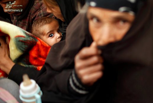 یک کودک آواره عراقی در کنار خانواده اش منتظر رفتن به محل امن در غرب موصل
