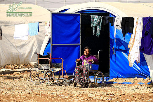دختر معلول و آواره عراقی بر روی یک ویلچر در اردوگاه حمال القلیل جنوب موصل