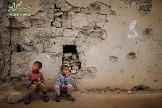 دو پسر عراقی نشسته مقابل خانه خود در جنوب موصل