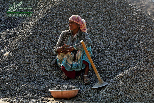 یک کارگر زن نشسته بر روی سنگهای ساختمانی - بمبئی، هند