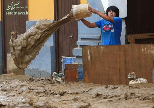 مرد پرویی در حال تخلیه سیل با سطل از خانه اش در لیما