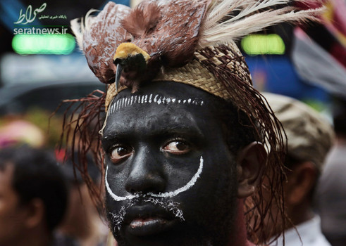 یک فعال پاپوا با پوششی فانتزی و سنتی و یک پرنده بر روی سر در تظاهرات ضد آمریکایی - جاکارتا، اندونزی