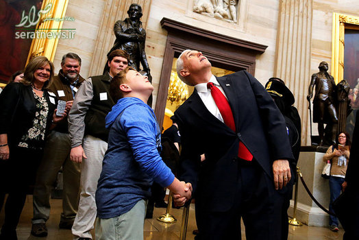 مایک پنس معاون دونالد ترامپ رییس جمهور آمریکا با یک توریست جوان در حال نگاه کردن به سقف مدور ساختمان کنگره (کاپیتول)