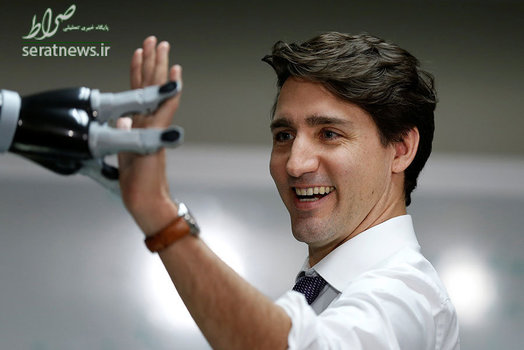  جاستین ترودو نخست وزیر کانادا در حال دست دادن با یک ربات در استان کبک