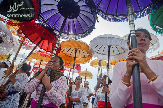 زنان چتر نگه دار در مراسمی در بالی اندونزی