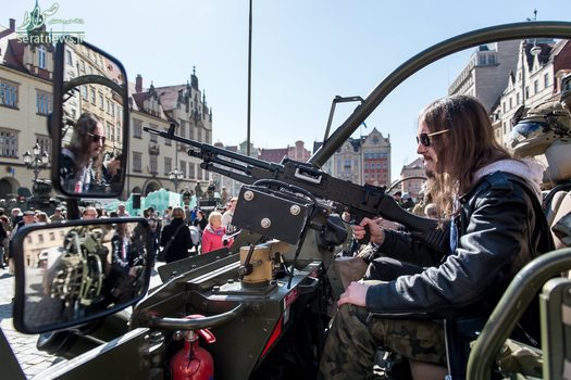 یک مرد نشسته در یک وسیله نقلیه نظامی در جریان برگزاری رژه نیروهای ناتو در لهستان