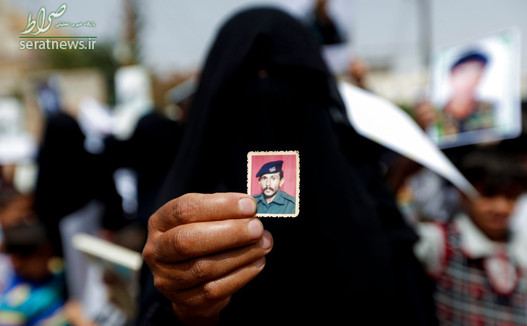 یک زن یمنی تصویری از اعضای خانواده خود را که در کنار نیروهای انصارالله می جنگیده و مفقود شده نشان می دهد