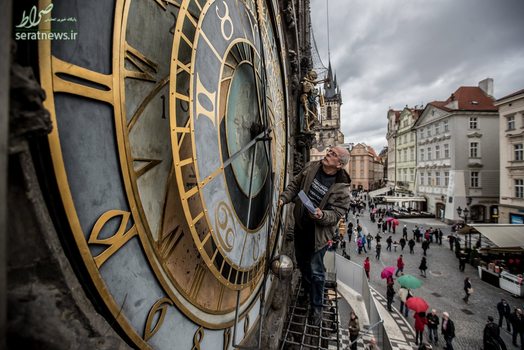 یک ساعت ساز در حال تنظیم کردن ساعت نجومی قدیمی شهر پراگ