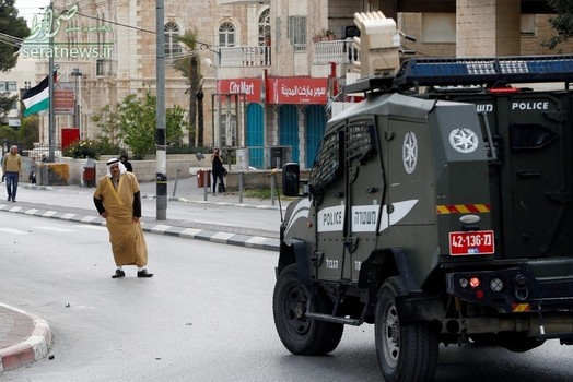 یک مرد فلسطینی ایستاده مقابل یک خودروی نظامی رژیم صهیونیستی در بیت لحم