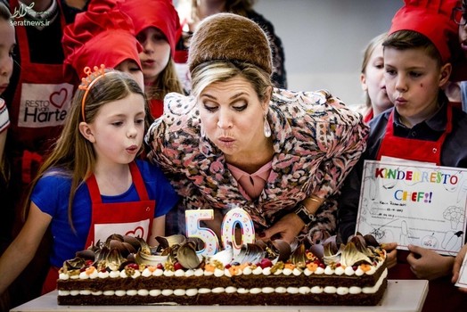 ملکه ماکسیمای هلند در حال فوت کردن شمع کیک به مناسبت پنجاهمین سالگرد افتتاح رستوران های زنجیره ای کودکان