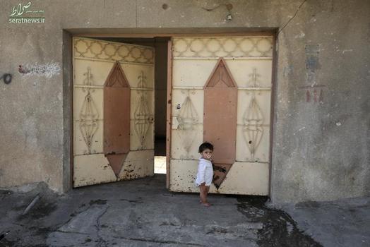 کودک عراقی ایستاده مقابل درب خانه اش در شرق موصل