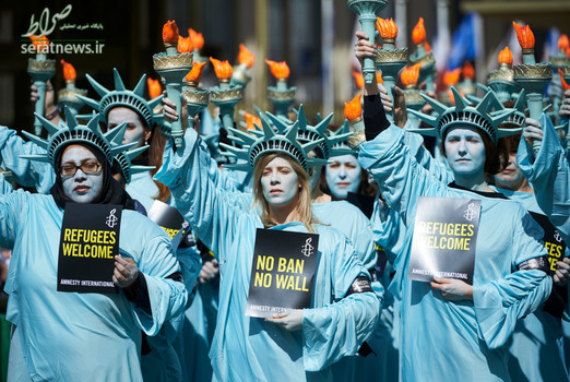 فعالان سازمان عفو بین الملل با پوشیدن لباسی شبیه مجسمه آزادی مقابل سفارت آمریکا در لندن علیه دونالد ترامپ  تظاهرات کردند