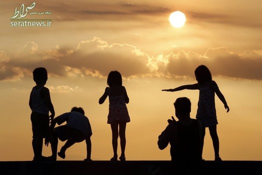 کودکان ایستاده کنار یک ساحل در غروب آفتاب - مانیل، فیلیپین